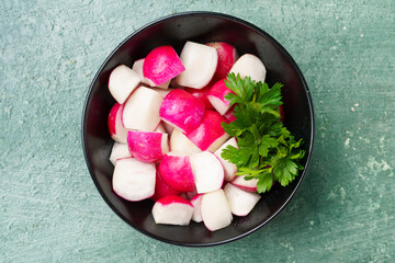 juicy radish in a bowl close-up, cut into pieces