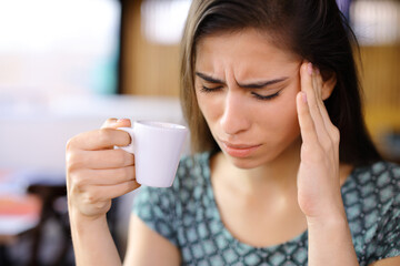 Woman drinking coffee suffering head ache