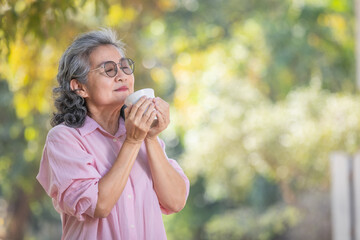 Naklejka premium asian senior woman with coffee