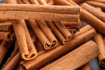 Cinnamon sticks against the background of a gray stone table.