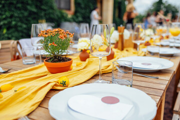 hairs and a table for guests, decorated with candles, are served with cutlery and crockery