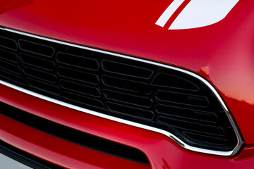 Compact, stylish and youthful five-door crossover in bright red color with white stripes across the...