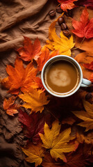 A cozy coffee cup surrounded by colorful autumn leaves on a textured fabric background.