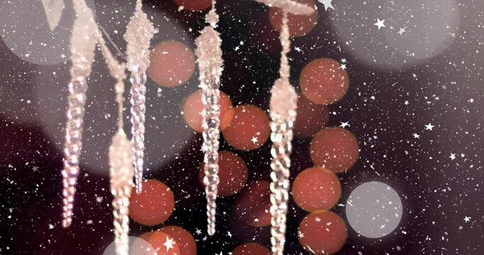 Animation of falling snowflakes over christmas decoration and bokeh lights