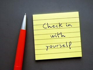 Note paper on gray background with handwritten text - Check in with yourself - carving out time...