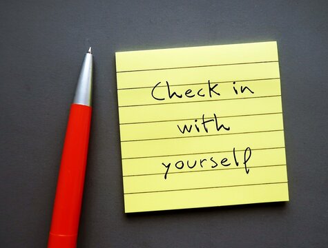 Note paper on gray background with handwritten text - Check in with yourself - carving out time each day to ask yourself how you’re doing