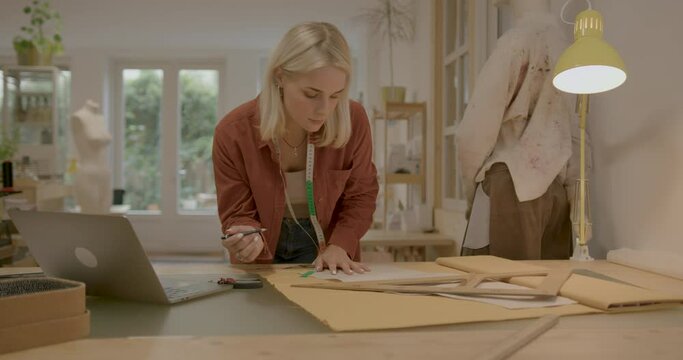Female Fashion Designer using Laptop in Atelier