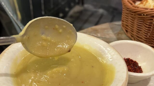 Super close-up of the ladle mixing a pumpkin soup puree in slow motion Keema curry, Short video clip. High quality