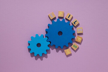 Two blue wooden gears, epilepsy day concept