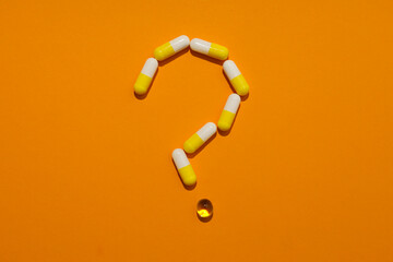 Question mark made of pills on a yellow background