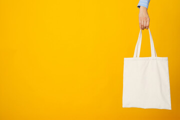 White bag in hand on yellow background