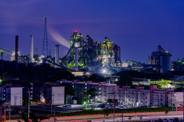 Giant cement plants illuminated at night.