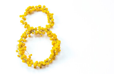 Obraz premium International Women's Day. A banner, a flyer, a beautiful postcard for March 8th. Yellow mimosa flowers in the shape of the number eight on a white isolated background.