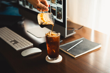 Iced coffee in a mug on the work desk at home