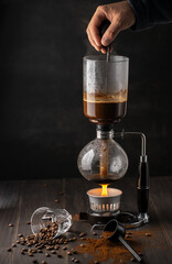 Obraz na płótnie Canvas Process of coffee bewing,stirring. Japanese Siphon Vacuum.