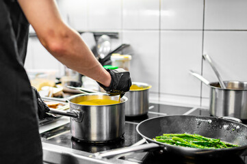 Chef hands cooking cheese sauce in the restaurant kitchen
