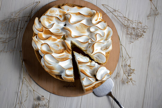 Top view of delicious lemon meringue tart on plate on white background