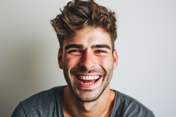 Obraz premium A man with a bright smile holds a toothbrush in his mouth. Perfect for dental hygiene concepts