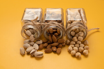 Mix of nuts: almonds,pistachios and hazelnuts on a yellow background.Template
