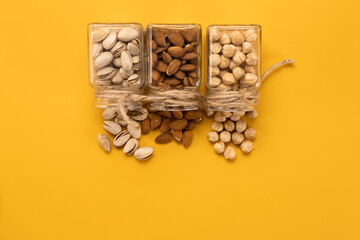 Mix of nuts: almonds,pistachios and hazelnuts on a yellow background.Copy space