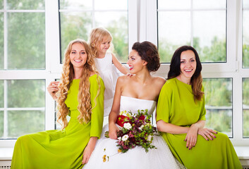 Cheerful bride with female friends and little flower girl