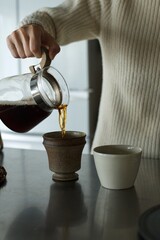 ドリップし終えたコーヒーをカップに移すところ