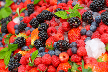 Blackberry, strawerry, raspberry, ice and green leaves background