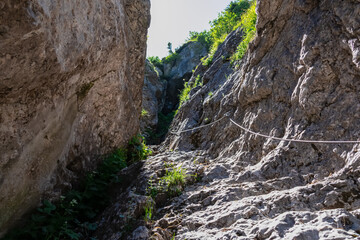 Fototapeta na wymiar Scenic via ferrata hiking trail to mount Mangart (Mangrt), Julian Alps, Friuli Venezia Giulia, Italy, Europe. Climbing through treacherous rugged mountainscape amidst extreme alpine terrain in summer