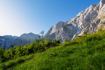 Fototapeta na wymiar Scenic hiking trail on alpine meadows to mount Mangart (Mangrt), Julian Alps, Friuli Venezia Giulia, Italy, Europe. Walking through majestic rugged mountains amidst extreme alpine terrain in summer