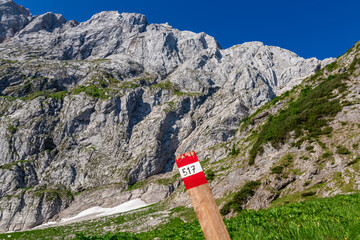 Path mark inidcating hiking trail from Fusine Lake to Mangart saddle in Tarvisio, Julian Alps, Friuli Venezia Giulia, Italy, Europe. Rugged mountain rock formations on extreme alpine terrain in summer - obrazy, fototapety, plakaty