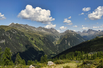 Bergpanorama, Berge mit blick ins Tal, Blauer Himmel mit kleinen Wolken, Baumgrenze