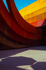 Abstract view of a modern sculptural architecture with vibrant red and yellow curves.