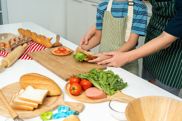 Young handsome asian man chef cooking breakfast in the kitchen. Happy asian man preparing food with ingredient. Chef in uniform in the kitchen.