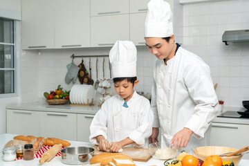 Young handsome asian man chef cooking breakfast in the kitchen. Happy asian man preparing food with ingredient. Chef in uniform in the kitchen.