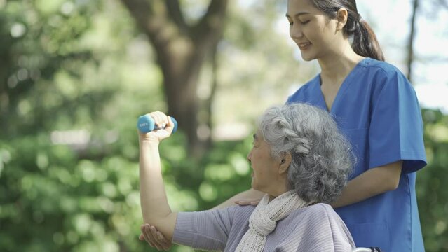 Professional physiotherapist taking care of asian senior patient during rehabilitation.