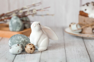 Stylish grey Easter eggs in the colors of marble, concrete, willow branches, Easter bunnies and Easter cake on a white wooden background. Coloring eggs for Easter.  The feast of bright Easter.