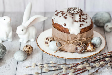 Fototapeta na wymiar Stylish grey Easter eggs in the colors of marble, concrete, willow branches, Easter bunnies and Easter cake on a white wooden background. Coloring eggs for Easter. Easter 2024.