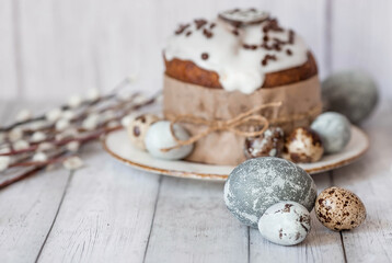 Stylish grey Easter eggs in the colors of marble, concrete, willow branches, Easter chicken and Easter cake on a white wooden background. Coloring eggs for Easter. The feast of bright Easter.