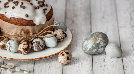 Obraz na płótnie Canvas Stylish grey Easter eggs in the color of marble, concrete, willow branches and Easter cake on a white wooden background. Coloring eggs with natural dye karkade tea. The feast of bright Easter.