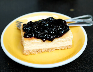 tasty blueberry cheesecake on yellow plate