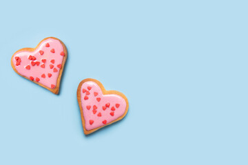 Valentines day greeting card with glazed heart shaped cookies on blue background. Top view. Copy space.