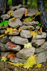 Stacked stones decorated with yellow, green and orange maple leaves