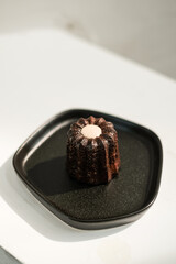 Canele cake, French dessert on black plate