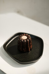 Canele cake, French dessert on black plate