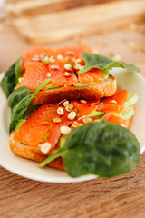 Fresh smoked salmon on toast with spinach and seeds