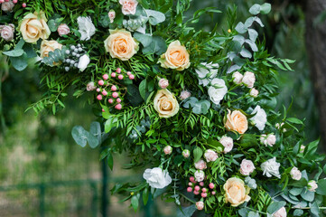 Details of the wedding arch. Flower arrangement consists of different types of roses, pink hypericum berries, silver brunia, and other plants. - 706329147