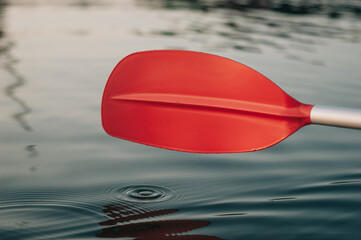 Close up of kayak oar above the water surface of the river.