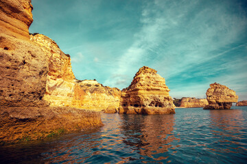 Coastal rocky seascape. Rocky shore near Praia da Marinha beach and Benagil in Algarve region in Atlantic ocean, Portugal, Europe