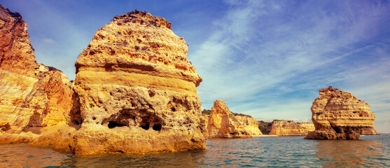Coastal rocky seascape. Rocky shore near Praia da Marinha beach and Benagil in Algarve region in...