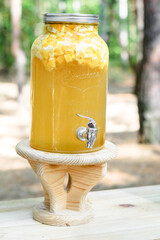 Lemonade jar on wooden table outdoors. - 706331327